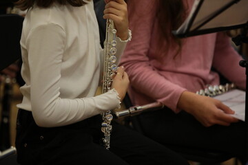 A girl holding a flute at a lesson in the classroom.The concept of musical school education of...