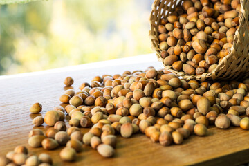 Hazelnuts in a wicker basket on old wooden table