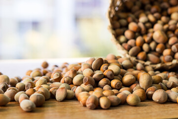 Hazelnuts in a wicker basket on old wooden table