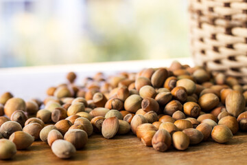 Hazelnuts in a wicker basket on old wooden table