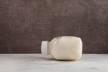 Spoiled curdled milk, bloated bottle. Concept - Improper storage of food. Expired dairy and...