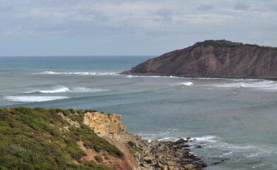 Paisagem de costa marítima com enseada, mar céu com nuvens e montanhas