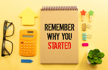 Remember why you started, text like planning on notepad and wooden table with clock.