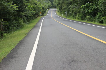 Fototapeta na wymiar Asphalt road curve in the forest
