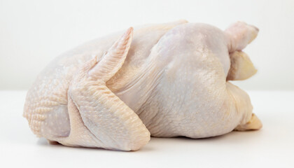Side view of a fresh broiler chicken on a white background.