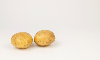 Two fresh young potatoes isolated on a white background.