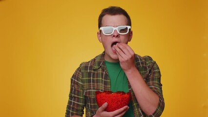 Excited tourist man in 3D glasses enjoying eating popcorn and watching interesting tv serial sport game, film, online social media movie content. Young boy isolated alone on yellow studio background