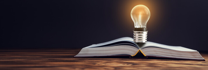 Glowing light bulb in an open book