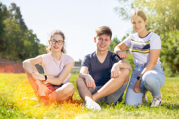 Portrait of positive teenagers on the summer green lawn