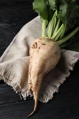 Fresh sugar beet with leaves on black wooden table