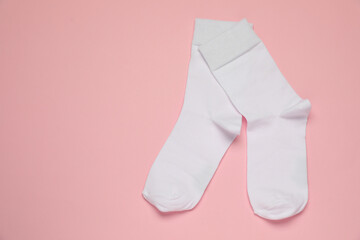 White socks on pink background, flat lay. Space for text