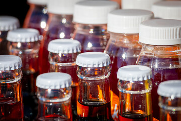 Bottles of drinks on the store shelf. White caps, red drink. Beverage vending in a supermarket or grocery store. Selected focus