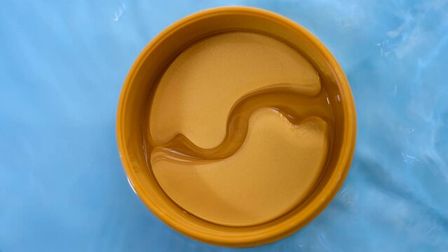Transparent patches under in round jar top view, concept of moisturizing and skin care.