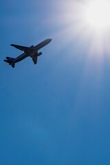 青空のコピースペースに太陽と旅客機