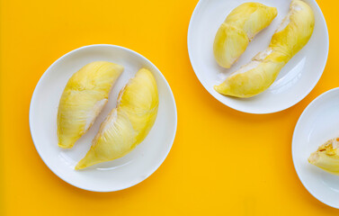 Fresh ripe cut durian on yellow background.