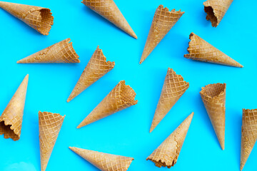 Empty ice cream cone on blue background.