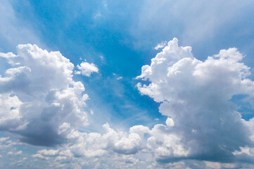 Fototapeta premium The vast sky and the white clouds float in the sky. The natural blue background has a breeze on a bright day in the summer.The sky and clouds are not the same shape as the weather.