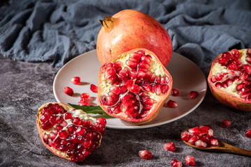 ripe pomegranate fruit with open pomegranate on table