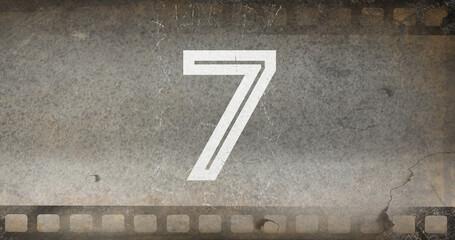 Composite of white colored number 7 text on old gray negative camera film, copy space