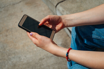 Woman's hands with a cell phone. Copy space. Landscape orientation.