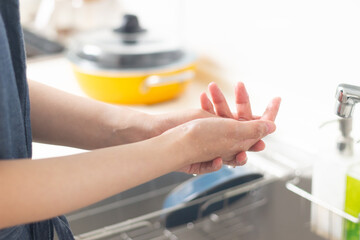 キッチンで手荒れを気にしている女性の手元