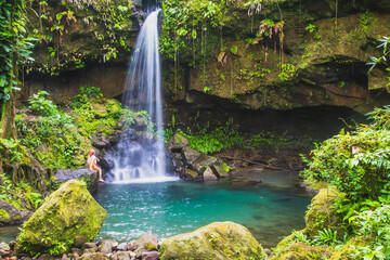 A swimmer enjoying Emerald Pool in the lush rain forest, the waterfall is a beautiful jewel of...