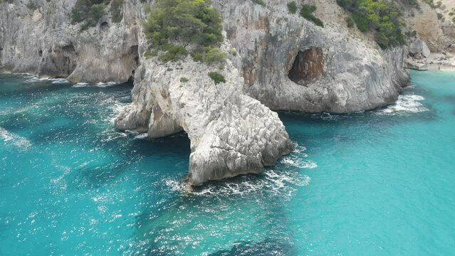 Aerial view of summer seascape with a beautiful sea grotto and clear blue emerald water top view. Travel cpncept. Sardinia, Italy