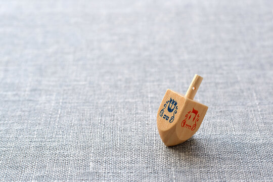 Hanukkah dreidel on grey linen background
