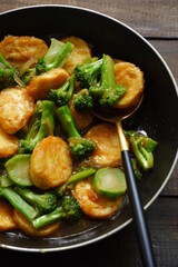  selective focus of stir fry of broccoli and tofu in a spoon 