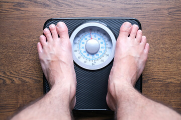 Legs of men standing on scales weight. Concept of health and weight loss.