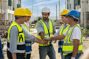 Foreman Engineers construction team wears a uniform, wears an engineer helmet for safety. The happiness team, the successful team join hands in the construction project of the house.