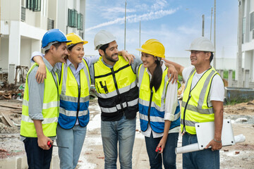  Foreman Engineers construction team in uniform wearing engineer helmets for safety is happy. The team has successfully completed the construction work of the house according to the plans in the house