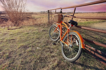 Fototapeta na wymiar Orange bicycle at the entrance to a bike trail in the countryside