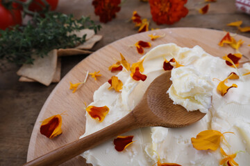 Butter board food trend, butter spread on wooden board with salt and marigold petals