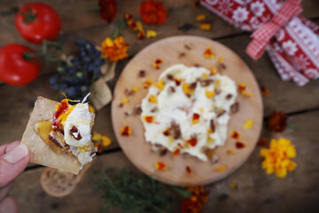 Butter board food trend, cracker with butter and toppings missing a bite - obrazy, fototapety, plakaty