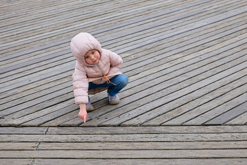 gregarious young girl is playing at the boardwalk in winter near Coney Island Park