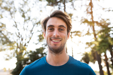 Portrait of young caucasian man in the forest looking at camera.