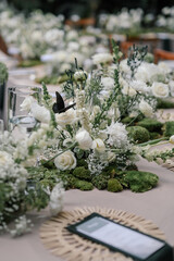 a beautiful wedding decoration arrangement. Table settings. Table Decoration for intimate private party outdoors with fairy light and white flowers. 