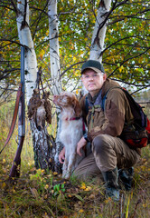 Portrait of a hunter with dogs on the hunt. Woodcock hunting with a pointing dog.  Hunting with an English setter.