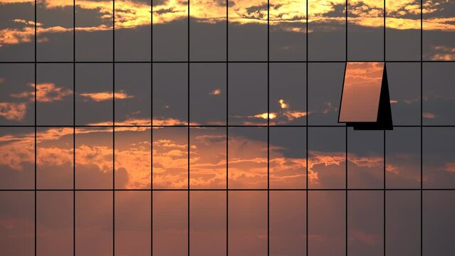 Sunset clouds mirrored in glass windows facade of business skyscraper building