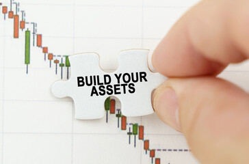 Against the background of the quotes chart, a puzzle with the inscription - Build Your Assets