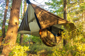 Ultralight hammock and quilt  sleep system set up under a shaped tarp in Killarney Provincial Park.