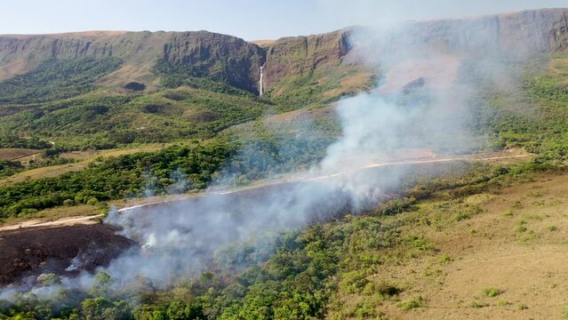 Drone view of Forest fire in Cerrado biome with Atlantic Forest transition near Casca d'Anta waterfall in Serra da Canastra National Park