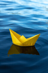 A small handmade paper boat floating on the water