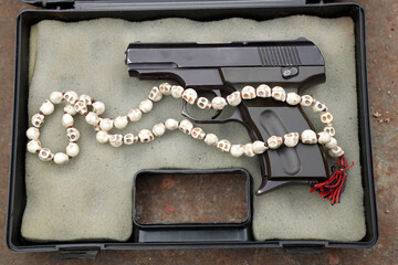 A pistol and rosary in case
