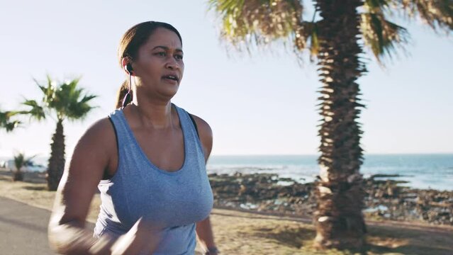 Fitness, music and running with woman at the beach in Miami for health, workout and sports. Motivation, exercise and training for weight loss with plus size runner from Puerto rico with earphones