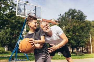 Father and his son enjoying together on basketball court.