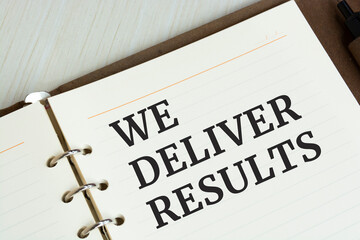 Word text WE DELIVER RESULTS on white paper