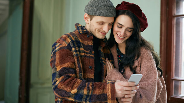 Young man and woman in love wearing stylish outfits taking selfie on smartphone camera horizontal shot 