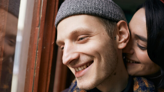 Horizontal close up portrait of happy Caucasian young man and his playful girlfriend smiling